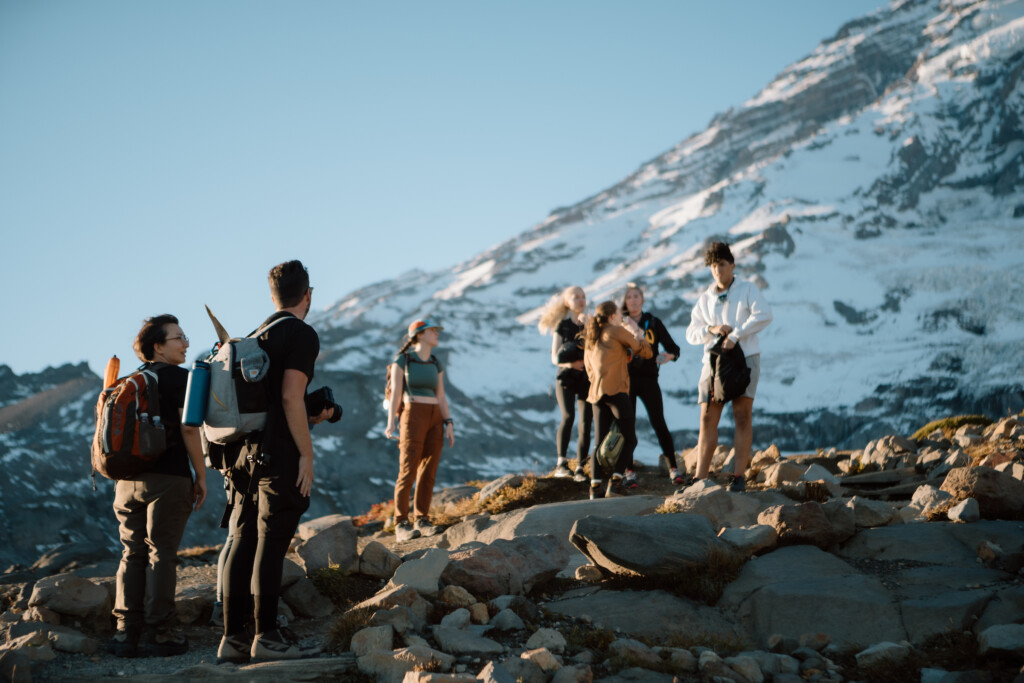 Students stand together in front of a mountain after a hike.