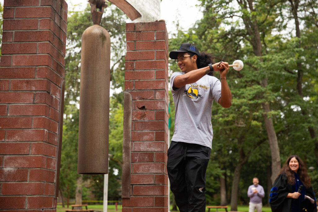 Student rings the bell outside.