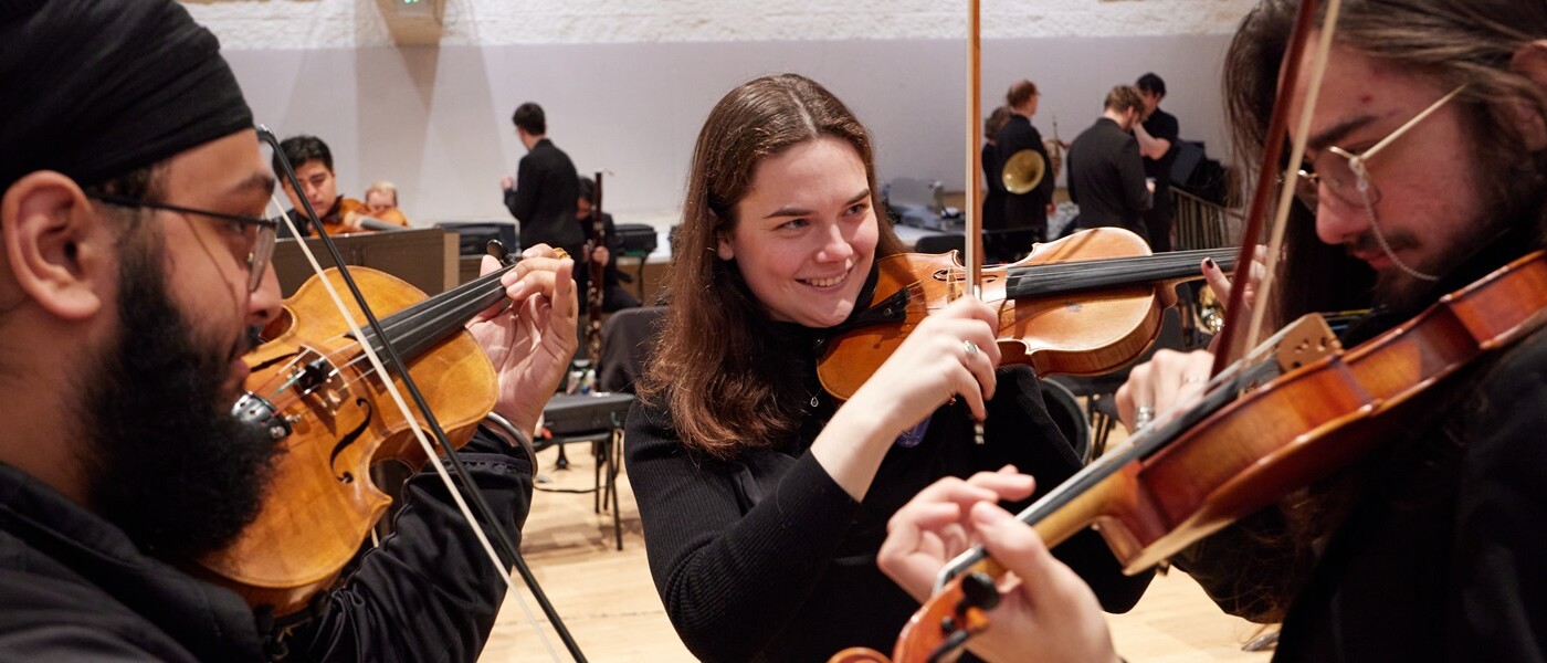 Three orchestra students prepare their violins during behind the scenes preparations before going on stage to perform Light, A PLU Christmas concert in Lagerquist Hall,