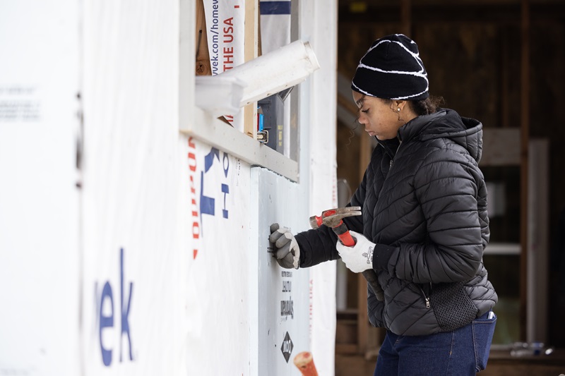 Student Ciara Itson installs insulation on a duplex at Habitat for Humanity site in Lakewood.