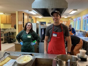 2 students serving dinner at Community Meal