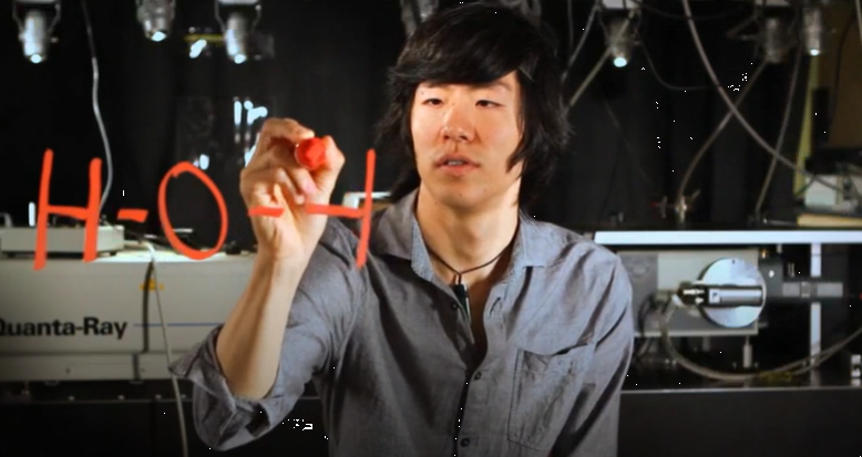 Dave Song writing a formula on a glass board