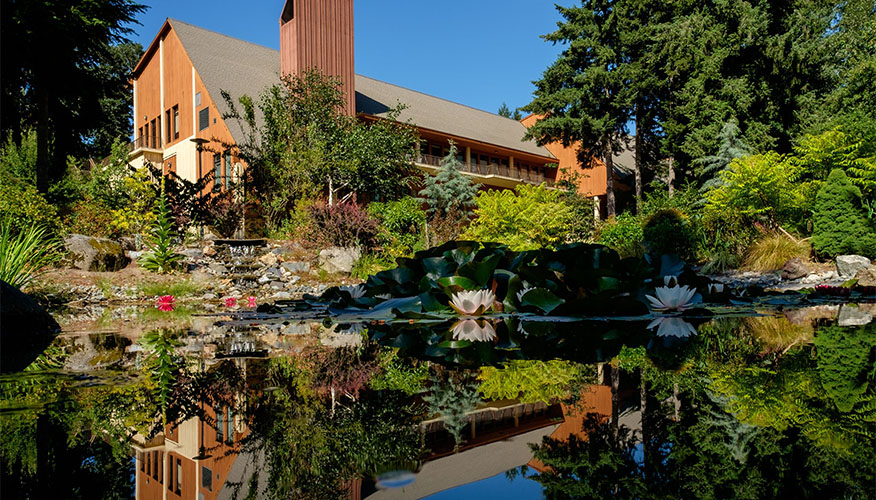 The Anderson University Center reflected in a pond.