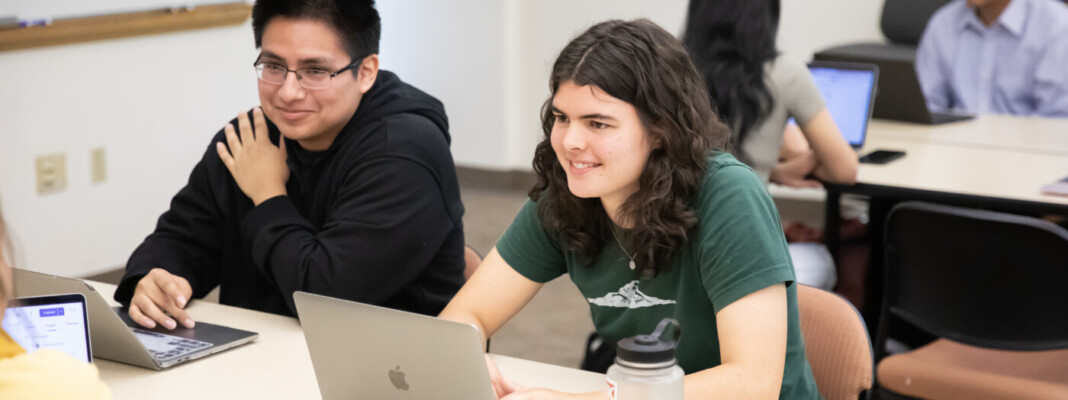 students work on group projects at their computers.