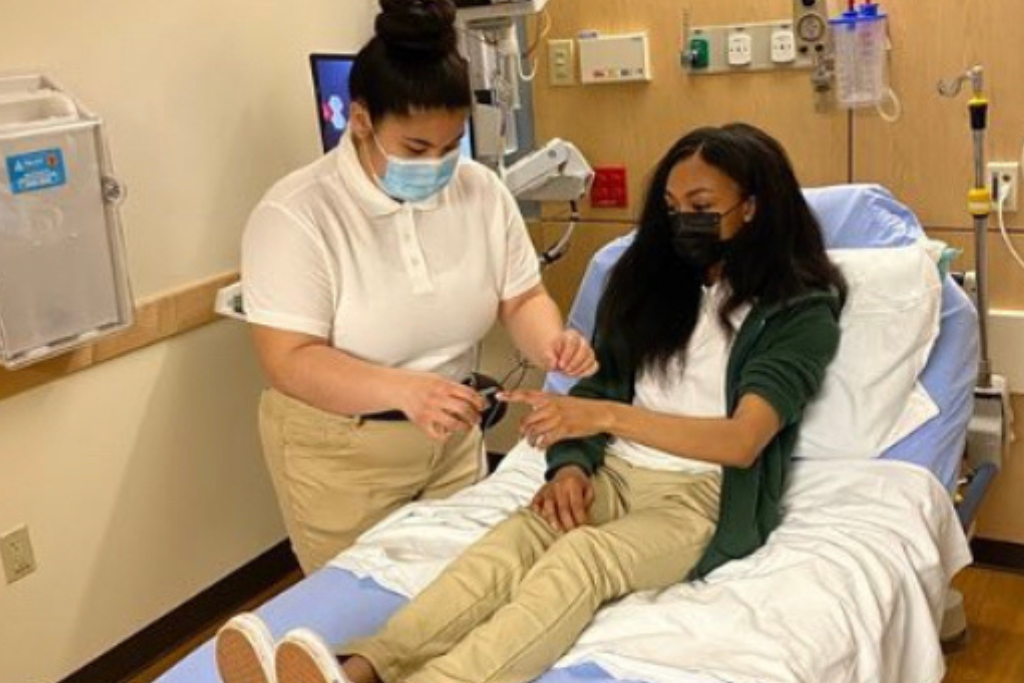 A nursing student is taking vitals on a patient.