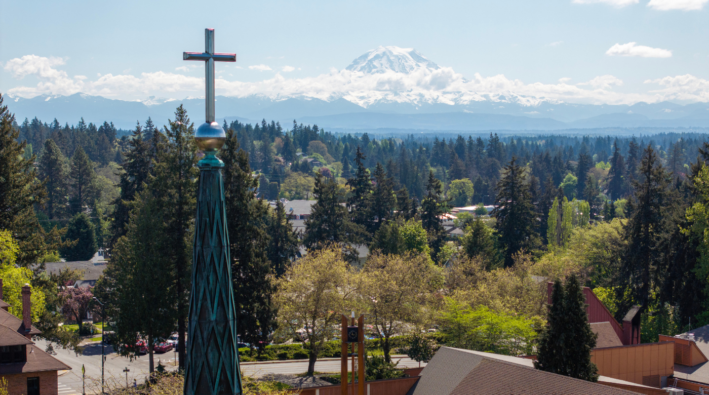 Drone photo of campus with mountain in the background, cross in the foreground