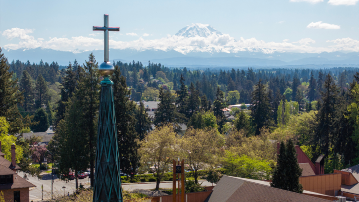 Drone photo of campus with mountain in the background, cross in the foreground