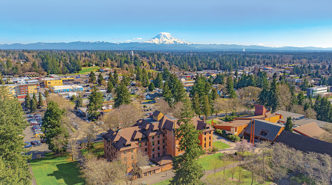 A drone image of PLU's campus showing Mt. Rainier and a blue sky in the background